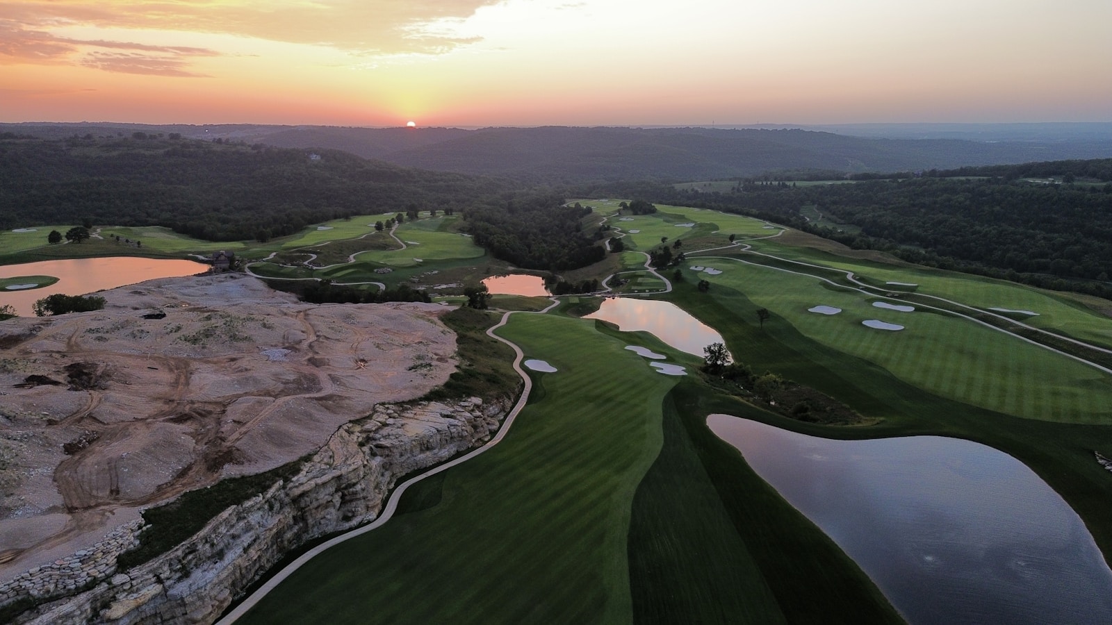 Aerial view of a golf course at sunset — the kind of venue the TOUR Championship auctions unlock